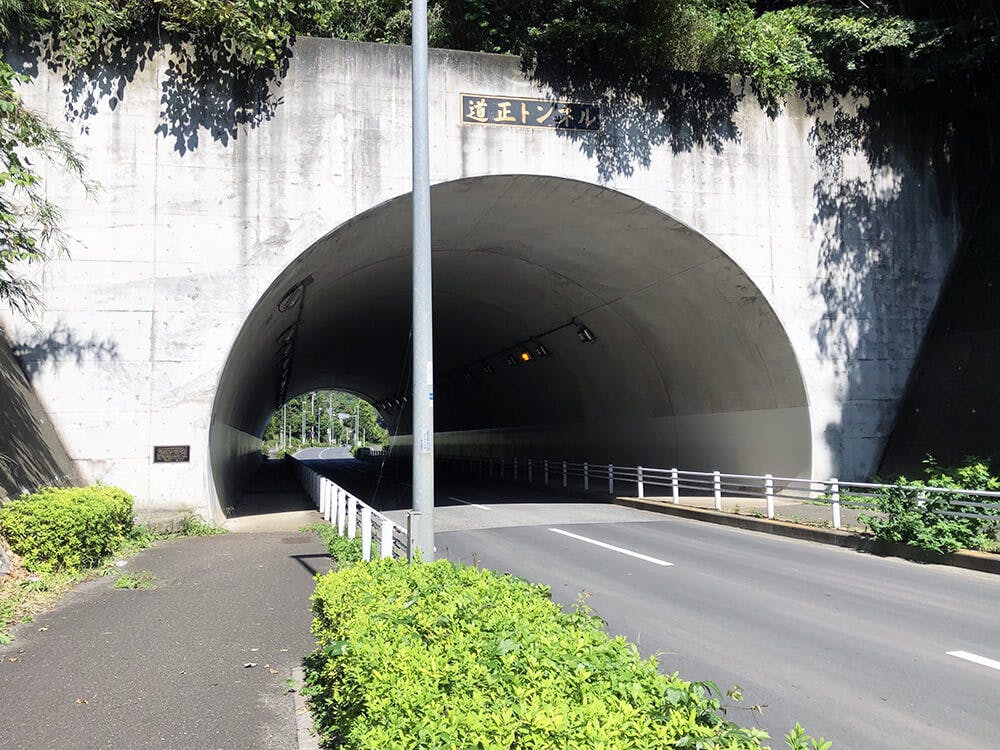 カーブを抜けると、道正トンネルがあります
トンネルを抜けると左手に北部斎場入口が見えてきます