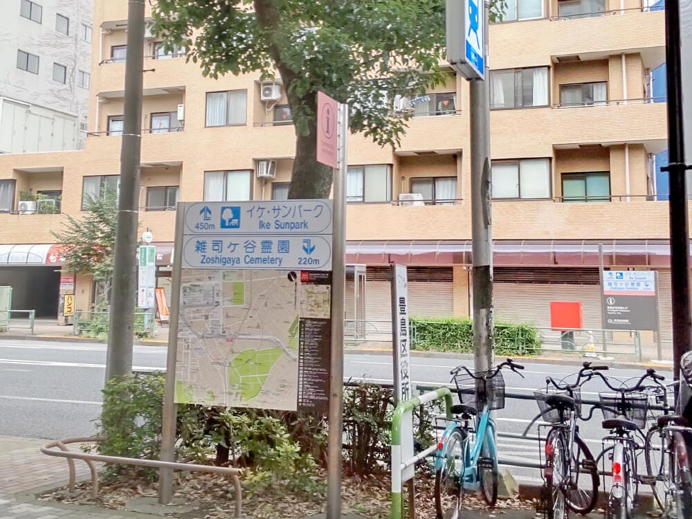 出口正面に地下鉄の看板、地図、雑司ヶ谷霊園（南池袋斎場）までの距離が書いてあります。右手に東京さくらトラム（都電荒川線）が見えます
