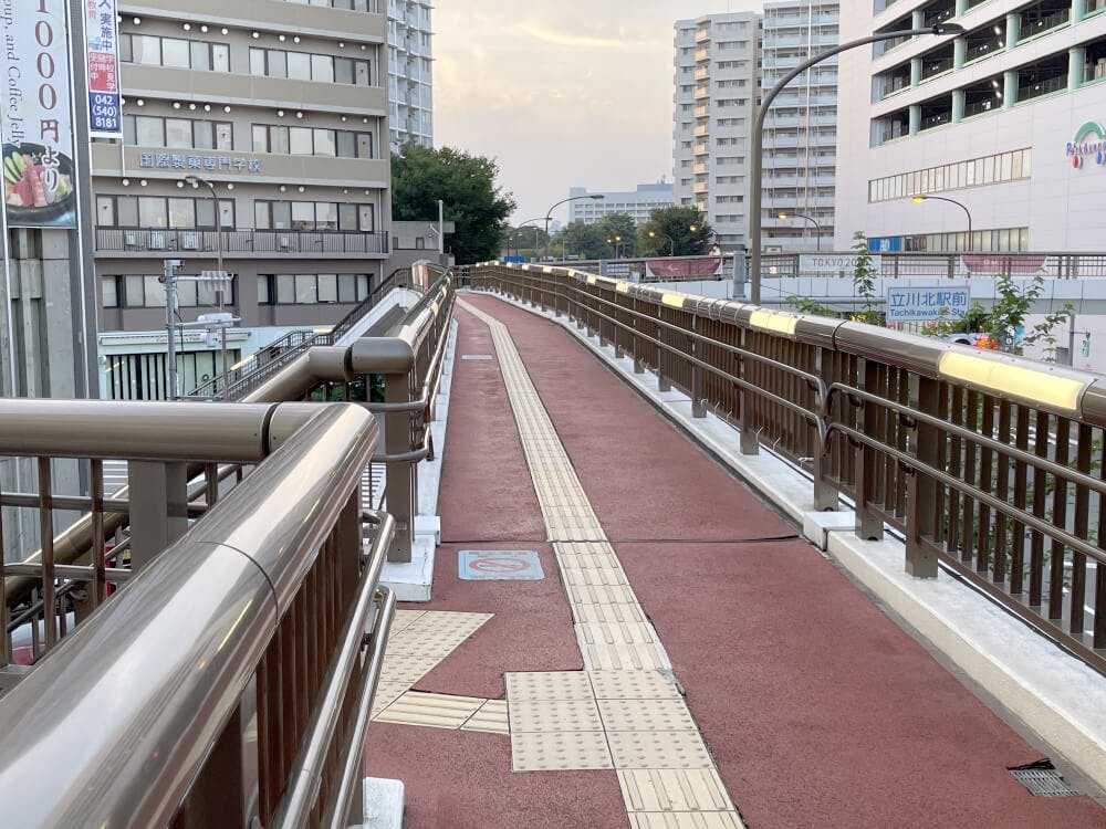 デッキ上から右手に立川北駅前の看板がみえます。看板手前左手の階段をおります。