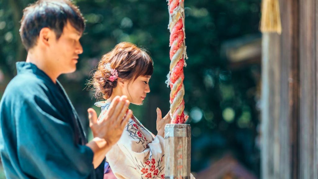 浴衣を着てお参りをする男女