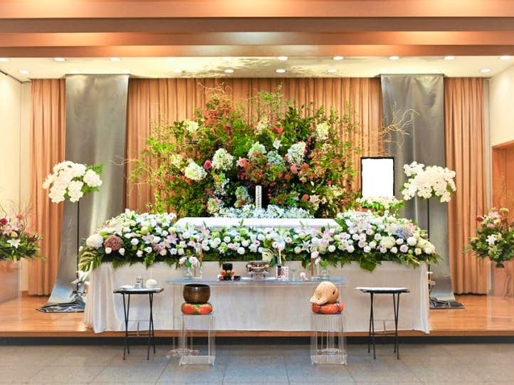 白と緑を基調とした花祭壇。棺の周りは白の花々。遺影の横には緑の木々が多く使われている
