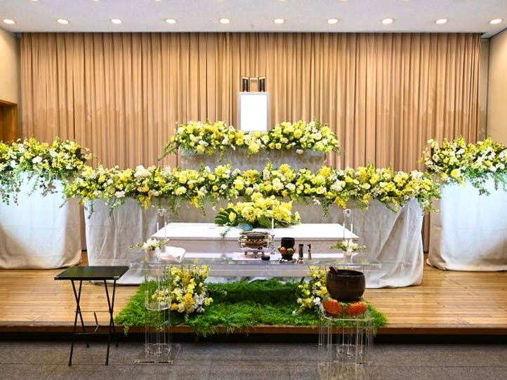 黄色を基調とした花祭壇。遺影や棺の周りは黄色の花々。足元は緑で覆われている